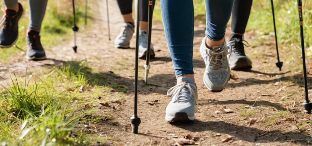 Bas des jambes de quatre marcheurs pratiquant une activité physique à travers la marche nordique